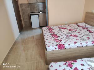 1 dormitorio con 2 camas con flores en las sábanas en Grandino rooms&apart, en Ulcinj