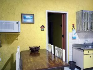 a kitchen with a wooden table and chairs and a sink at Hibisco Rosa Aluguéis in Araçatuba