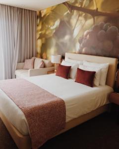 a bedroom with a large white bed with red pillows at Douro Castelo Signature Hotel & Spa in Lamego