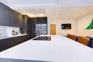 una cucina con piano di lavoro bianco in una camera di 5BR House in Romford with Free Parking a Romford