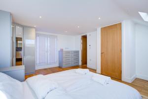 una camera bianca con un grande letto con due cuscini di 5BR House in Romford with Free Parking a Romford