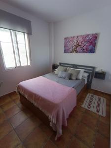1 dormitorio con 1 cama y una pintura en la pared en Atiko Welcome, en Arcos de la Frontera
