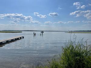 due persone in piedi in acqua vicino a un molo di Mamrowisko a Węgorzewo