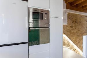 a kitchen with a refrigerator and a microwave at Mediterranean Gem Getaway in Valencia
