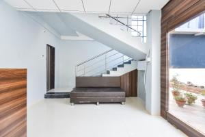 uma escadaria numa casa com paredes brancas e pisos de madeira em OYO Flagship Hotel Manish Inn em Aurangabad