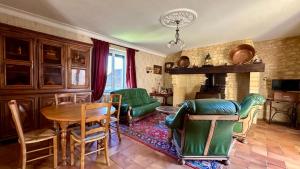 a living room with a table and chairs and a fireplace at Domaine Bois De Capy in Proissans