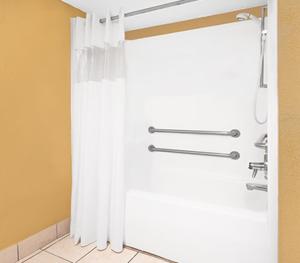 baño con ducha con cortina blanca en Travel Inn North Little Rock, en North Little Rock