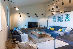 sala de estar con sofá azul y TV en CAN BUFÍ Espectacular casa con piscina interior, en Llagostera