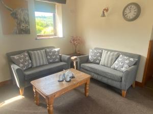 Sala de estar con 2 sofás y mesa de centro en Craven Garth Cottages, en Rosedale Abbey