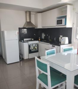 a kitchen with a table and chairs and a refrigerator at Departamento San Martin Ramallo in Ramallo