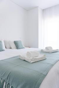 - deux serviettes blanches assises au-dessus d'un lit dans l'établissement SAL Baleal, à Baleal