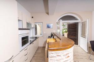 Una cocina con gabinetes blancos y una encimera de madera. en Apartments Serzane, en Zastražišće 48 fotos más