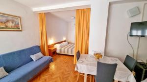 路巴奇的住宿－Apartments Poljubac，客厅配有蓝色的沙发和桌子