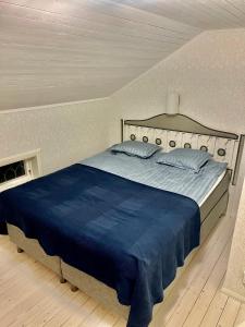 a bedroom with a large bed with a blue blanket at Lyxig oas med modern elegans in Mora
