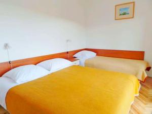 路巴奇的住宿－Apartments Poljubac，黄色毯子的客房内的两张床