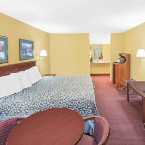 ノース・リトル・ロックにあるTravel Inn North Little Rockの大きなベッドとテーブルが備わるホテルルームです。