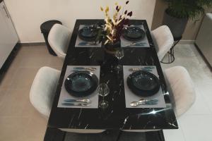 una mesa negra con sillas blancas y una mesa negra en Daloospa luxe 5*, en Drancy