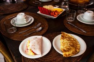 a table with plates of food on top at Casa Petunia Pousada Boutique in Salvador