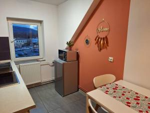 eine Küche mit einem Kühlschrank, einem Tisch und einem Fenster in der Unterkunft Top Apartment in Bielsko-Biała