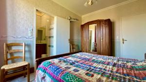 a bedroom with a bed and a chair and a mirror at Domaine Bois De Capy in Proissans