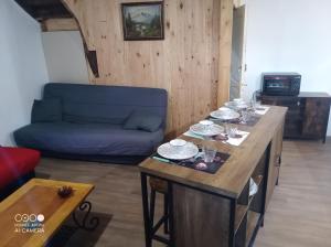 a living room with a table and a blue couch at Village où il fait bon de vivre in Mauléon-Barousse