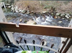 a view of a river from a wooden balcony at Village où il fait bon de vivre in Mauléon-Barousse +5 photos