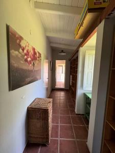 een hal met een rieten kruk en een schilderij aan de muur bij La Lomita, Calamuchita, un plan de tranquilidad y naturaleza plena in Cordoba