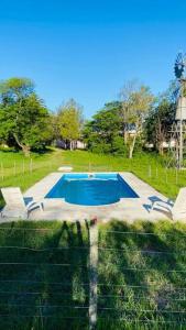 een zwembad in een veld naast een hek bij La Lomita, Calamuchita, un plan de tranquilidad y naturaleza plena in Cordoba