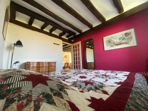a bedroom with a bed and a pink wall at Jolie maison de campagne au bord d'un ruisseau in Vinon