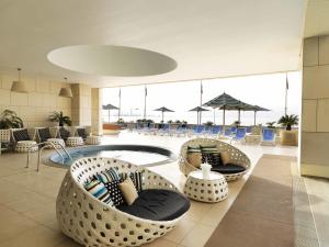 クウェートにあるSymphony Style Hotel Kuwaitのロビー(椅子とテーブルのあるプール付)