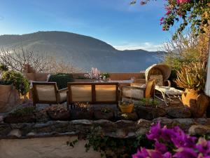 eine Terrasse mit Tisch und Stühlen und Blumen in der Unterkunft Rural House, heated pool & steam room, Casa Aloe. in Atalbéitar