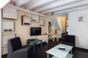 sala de estar con 2 sillas, TV y mesa en Il Pozzo di Santa Teresa, en Catania