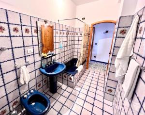 La salle de bains est pourvue d'un lavabo bleu et de toilettes. dans l'établissement Case vacanze Villa La Terrazza Sul Mare a Trabia, à Trabia