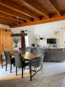 a dining room with a table and chairs and a couch at Charmante villa au calme entre mer et Cévennes Animaux de compagnie acceptés in Saint-Gély-du-Fesc