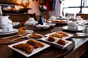 a wooden table with plates of food on it at Casa Petunia Pousada Boutique in Salvador
