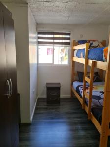 a room with three bunk beds and a window at departamento in Puerto Montt
