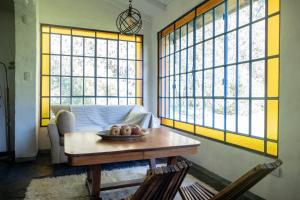 een woonkamer met een tafel en een aantal ramen bij Chacra Casa Quinta Carmen de Areco - La Alpargata in Carmen de Areco