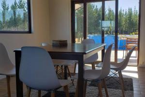 a dining room with a table and chairs with a view at Casa en condominio de parcelas in Yumbel