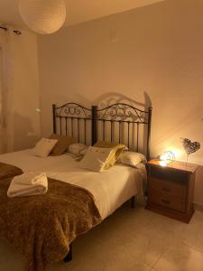 een slaapkamer met een groot bed en een nachtkastje bij APARTAMENTO PURI in Candeleda
