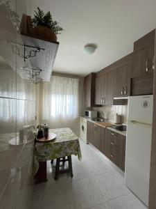 een keuken met een tafel en een witte koelkast bij APARTAMENTO PURI in Candeleda