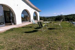dos sillas y una mesa en el césped junto a un edificio en El Vergel en Villa Giardino