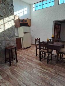 uma cozinha com uma mesa e cadeiras de madeira e uma mesa e uma mesa em El Vergel em Villa Giardino