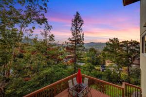 una terraza con una silla y una sombrilla en 5BD San Rafael Retreat w/ Billiards, BBQ, & Views! en San Rafael