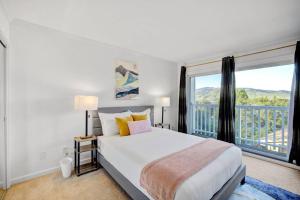 um quarto com uma cama e uma grande janela em 5BD San Rafael Retreat w/ Billiards, BBQ, & Views! em San Rafael