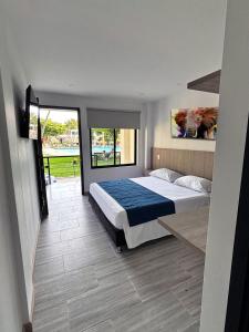 a bedroom with a large bed with a blue blanket at Hotel Las Victorias Palmira in Palmira