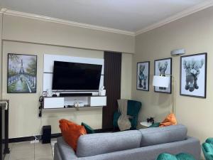 a living room with a couch and a flat screen tv at EliteStay at Casa De Barron in Kingston