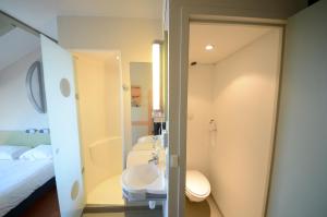 a bathroom with a toilet, sink, and bathtub at ibis budget Brive La Gaillarde in Brive-la-Gaillarde