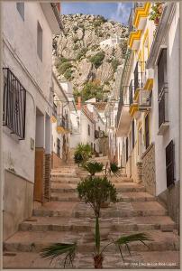 an alley with stairs and a mountain in the background at Casa Clara, Caminito de Rey in Valle de Abdalagís