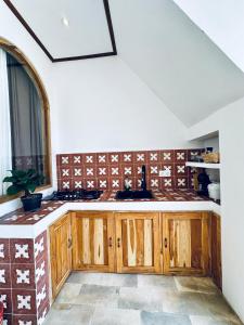 a kitchen with wooden cabinets and a window at La Plage Onirique Beachfront Nusa Penida in Nusa Penida