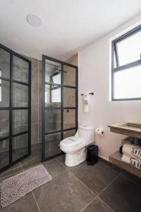 un bagno con wc e doccia in vetro di La Fábrica #3 Kokerei a Valle de Bravo